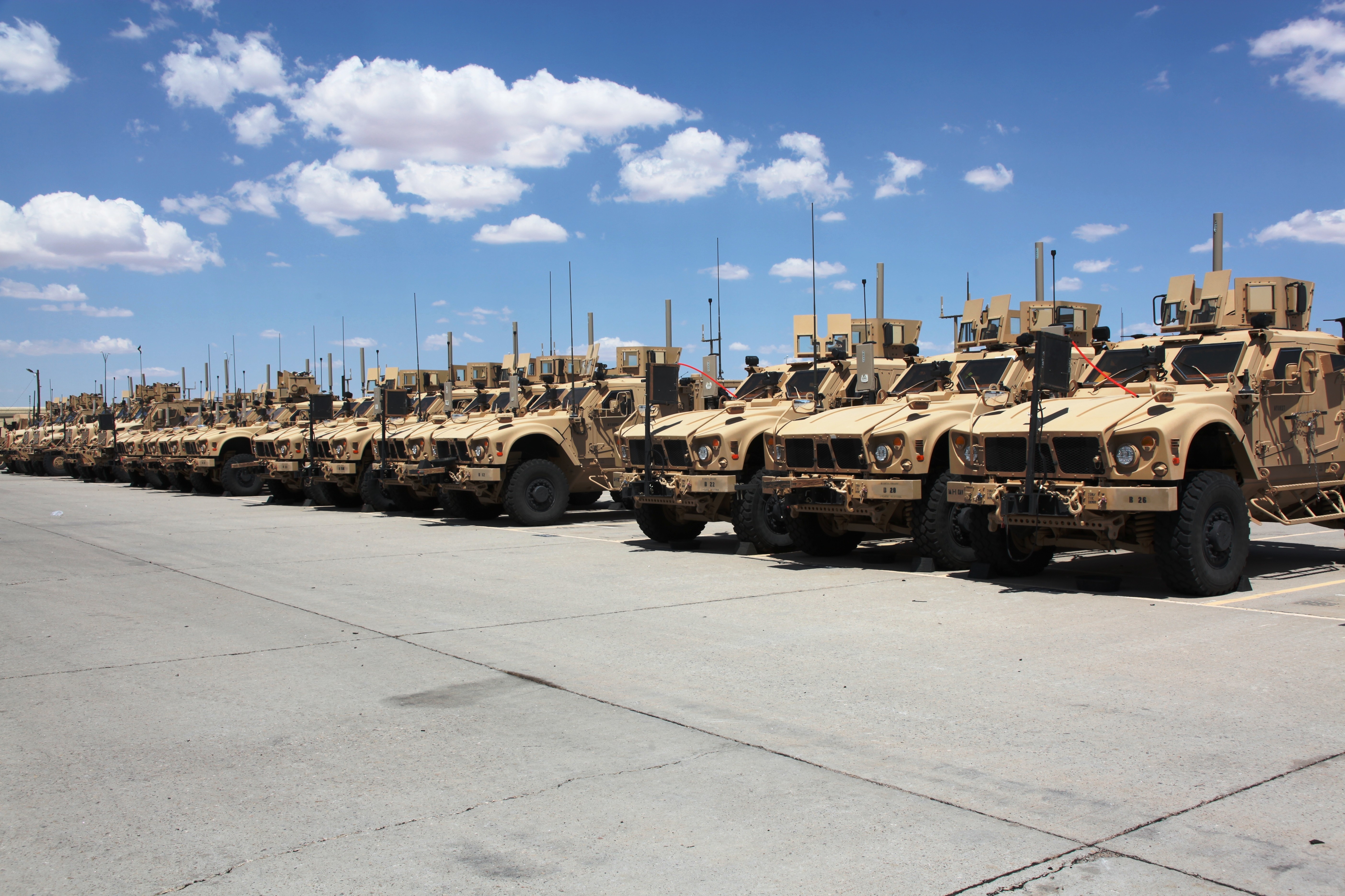Fleet of military tactical vehicles at a motor pool — The Military Fuel Vault protects every fuel filler